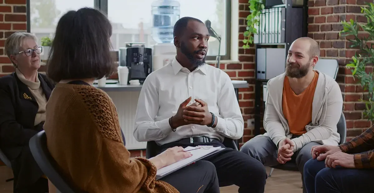 Colleagues in a supportive group conversation about wellbeing at work