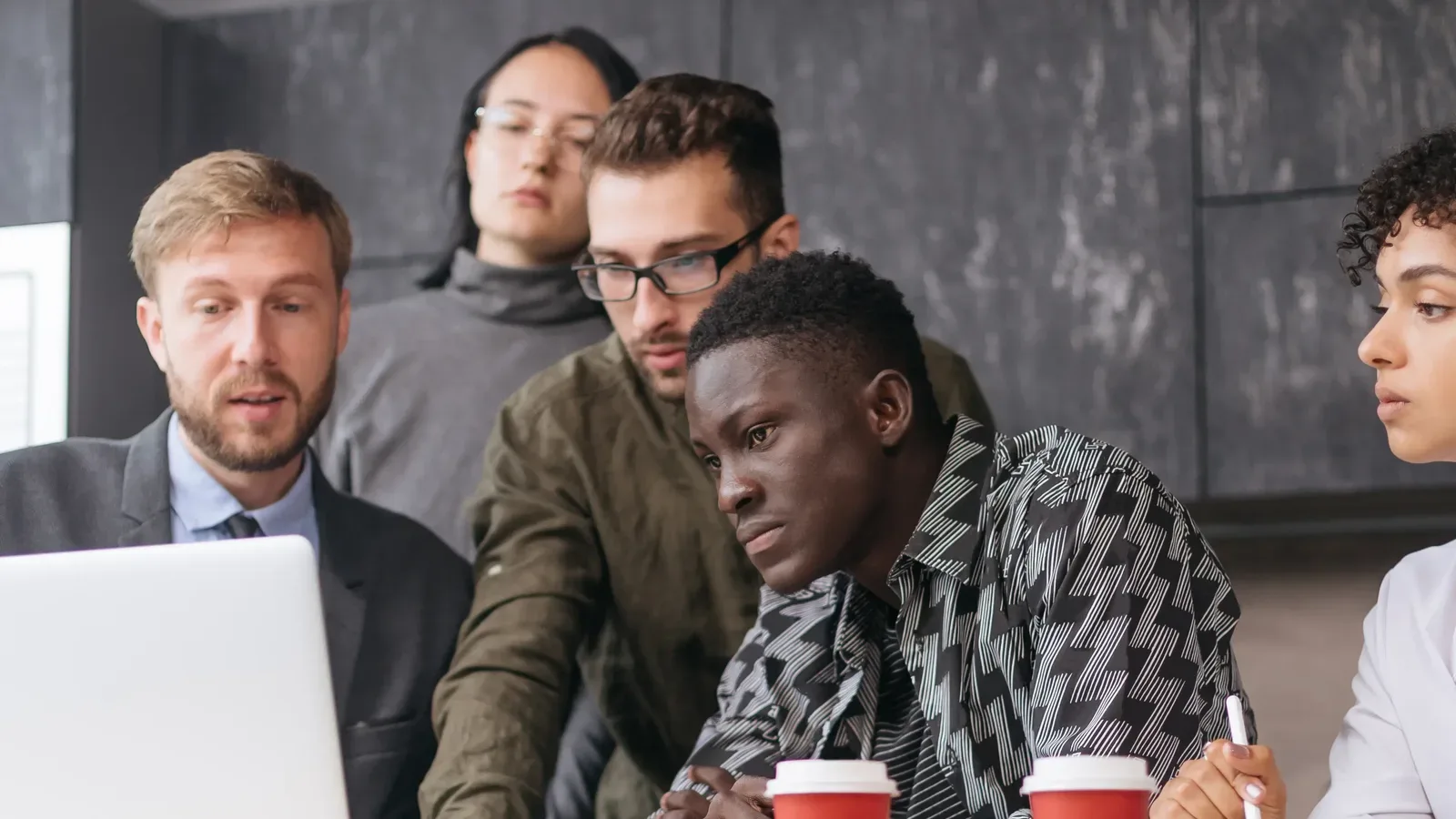 A team frowning over a laptop as they review their old compliance training